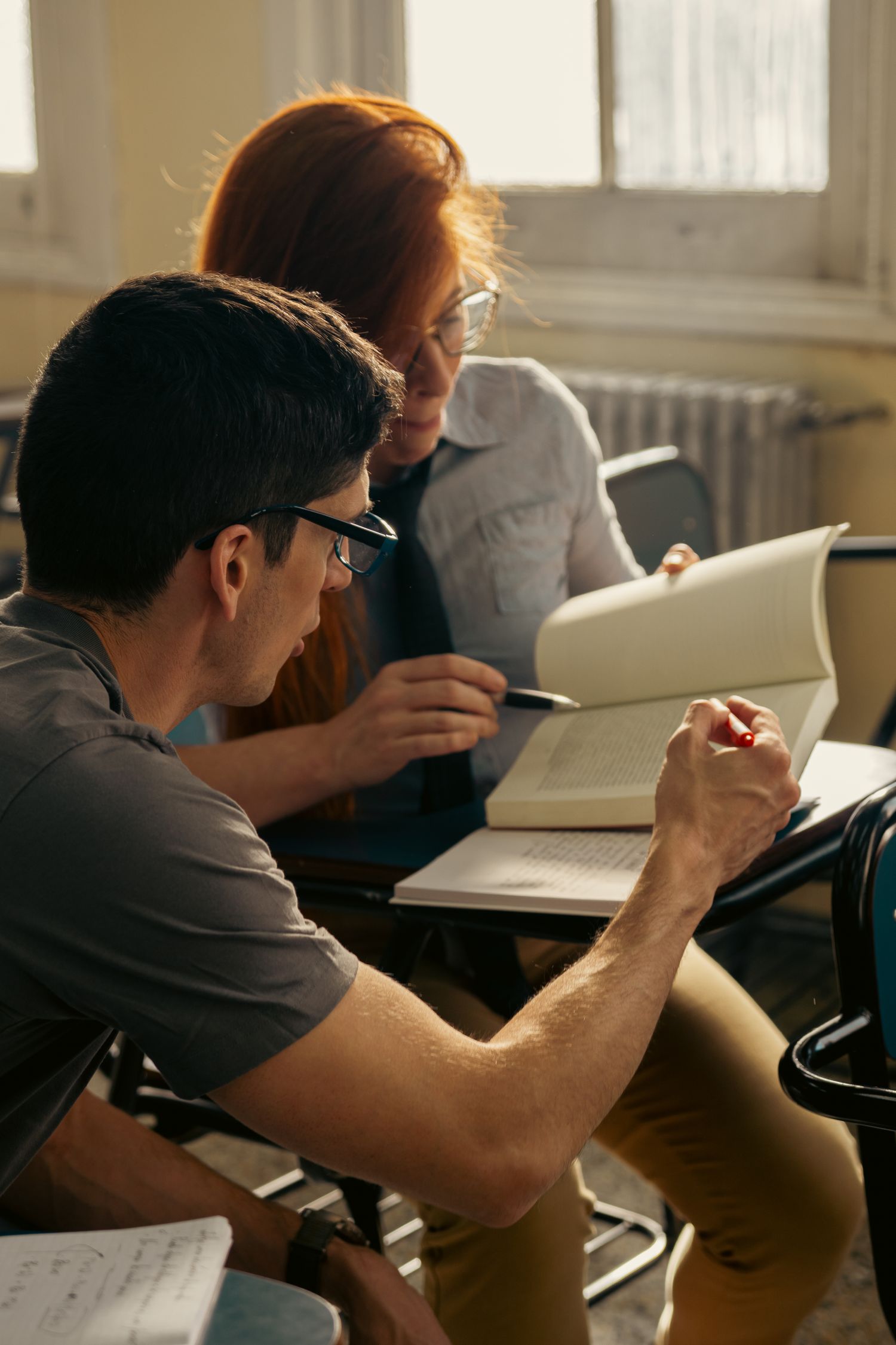 Two students discussing and reading a book in an academic setting in Buenos Aires.