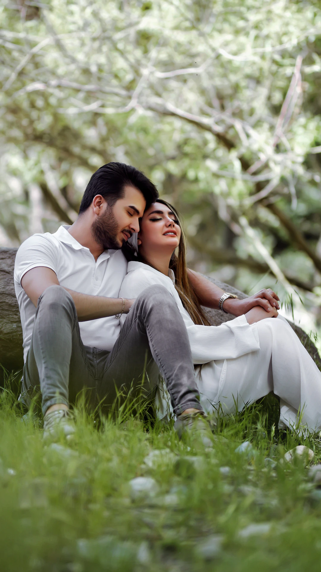 a man and a woman sitting next to each other in the grass