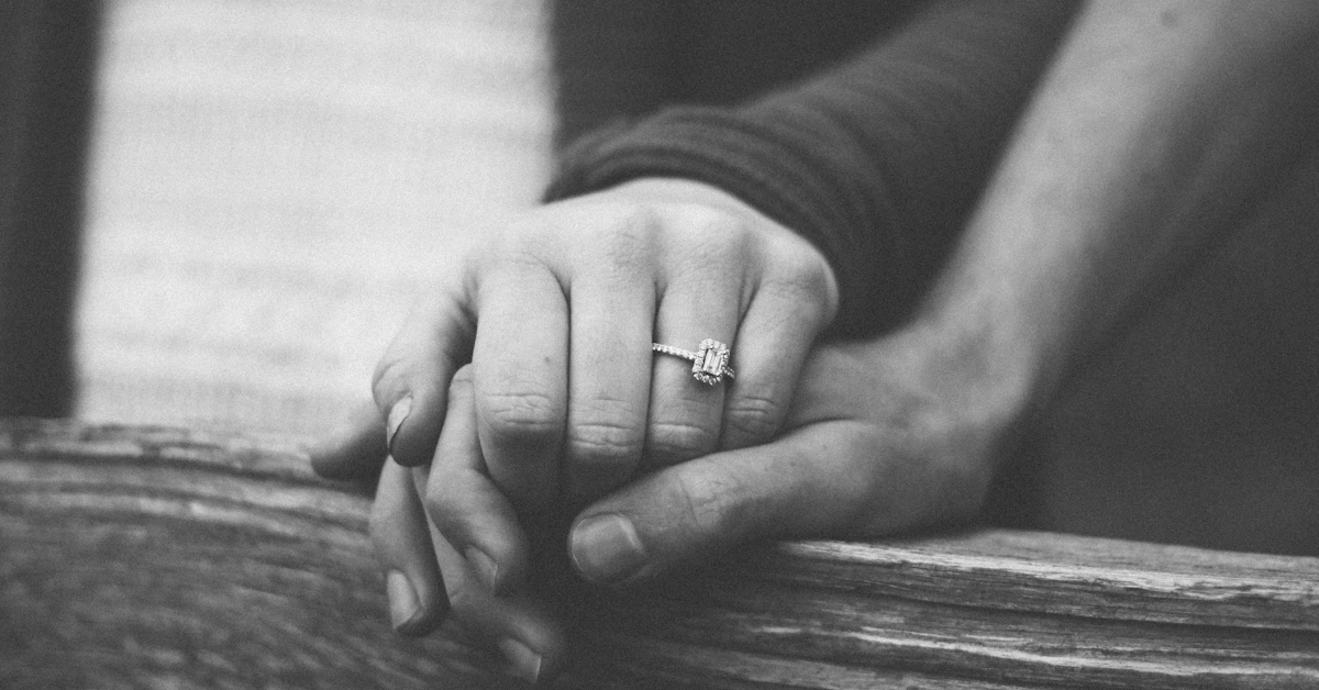 a couple holding hands with a wedding ring visible