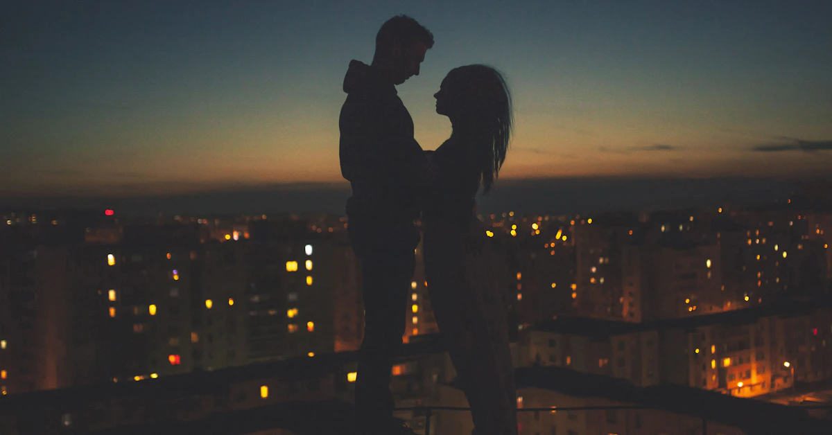 silhouette of man and woman standing on roof building